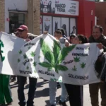 Integrantes de la comunidad sostienen una bandera por la salud, los derechos, la inclusión y la solidaridad