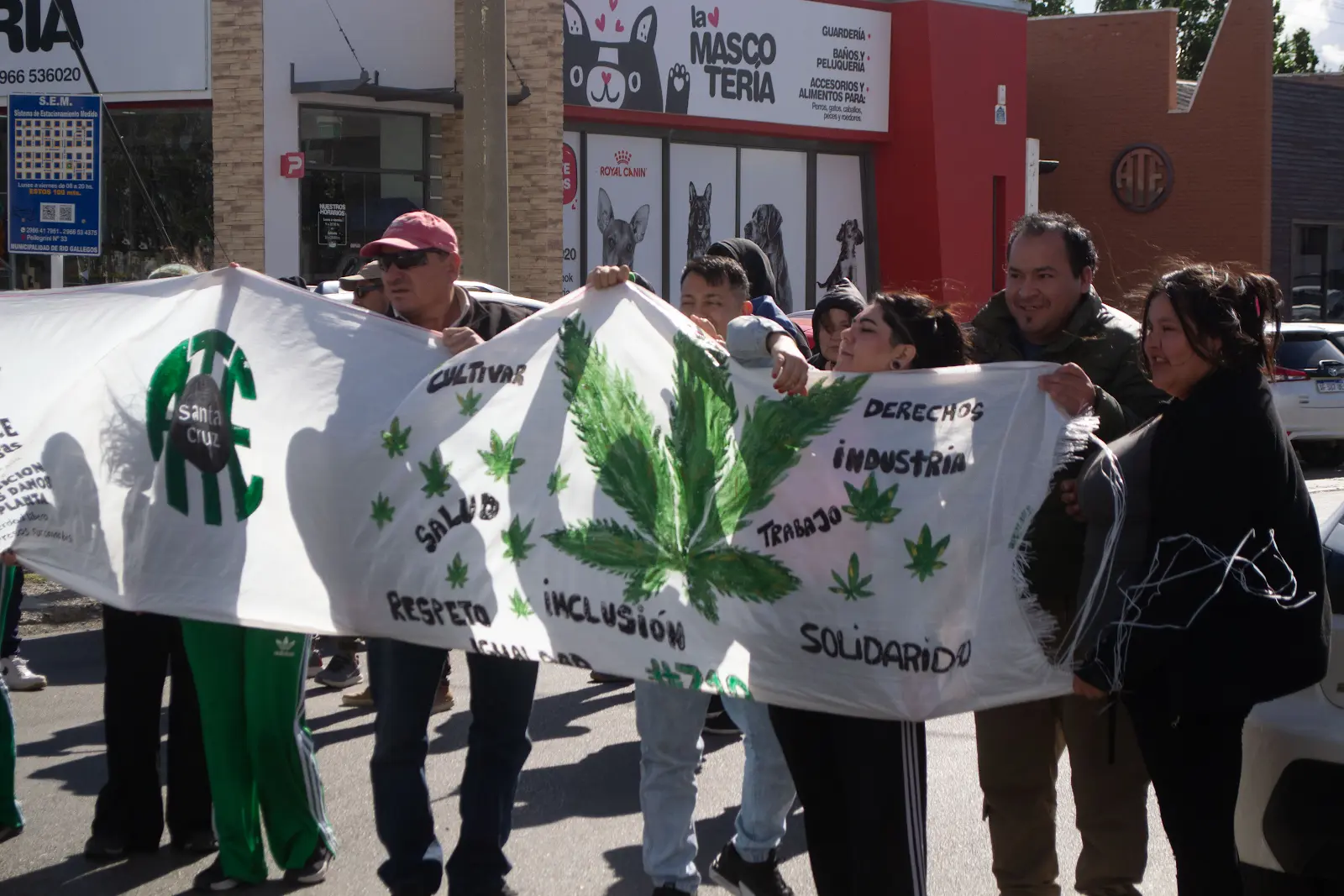 Integrantes de la comunidad sostienen una bandera por la salud, los derechos, la inclusión y la solidaridad