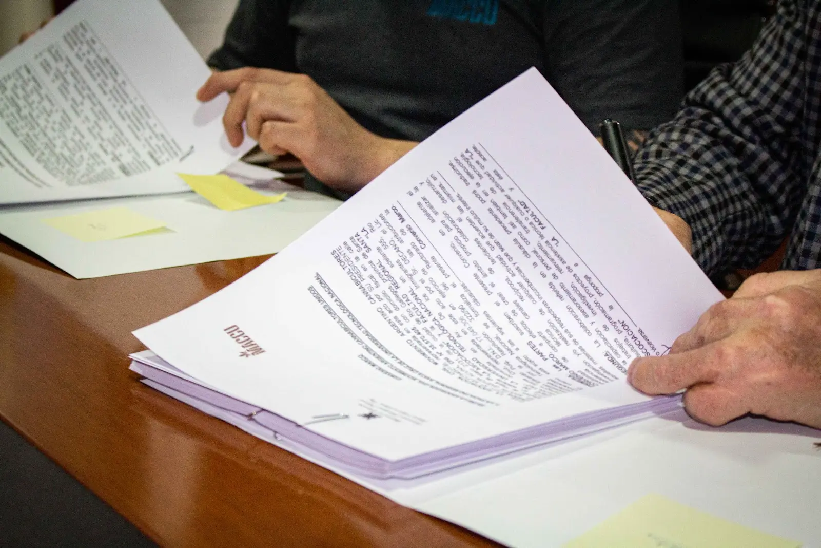 Personas revisan materiales educativos de MACCU durante una actividad comunitaria